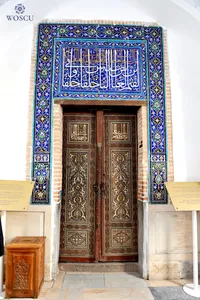 What do the inscriptions on the door leading to the complex of buildings near the mausoleum of Qusam ibn Abbas say?